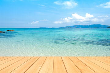 Empty wooden board table top with blurred beautiful blue or turquoise Ocean and beautiful blue sky.