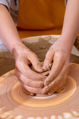 potter makes jar on the circle, vertical photo
