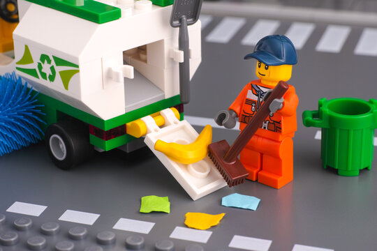 Tambov, Russian Federation - January 17, 2020 Lego cleaner with brush cleaning street and putting garbage in street sweeper truck.