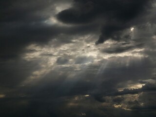 Dark sky with clouds. Rays of the sun through dark clouds.