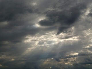 Dark sky with clouds. Rays of the sun through dark clouds.