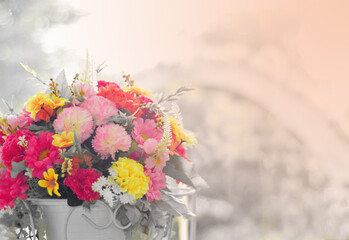 Bouquet of flowers in a white vase placed on a table by the window.  Copy space. Selective focus. Warm colors.
