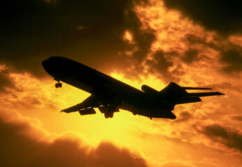 Fototapeta na wymiar Boeing 727 jet airliner on landing approach silhouetted against setting sun