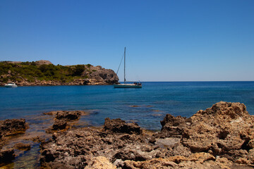 A ship sails into a bay on the Greek island of Rhodes