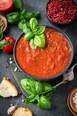 Fresh homemade tomato soup in the bowl on stone background