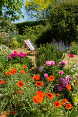 North Hampshire, England, UK. May 2020. An attractive English country garden and a deckchair in...