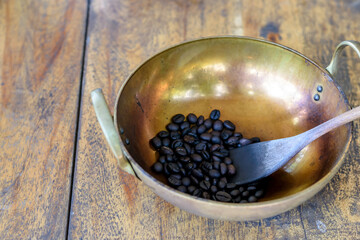 Roasted coffee beans in a brass pan on wooden table background. - 355905988