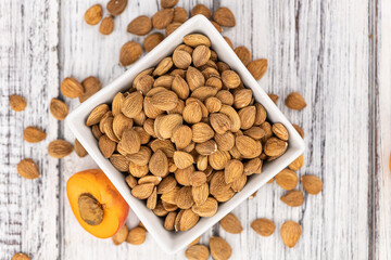 Vintage wooden table with shelled Apricot Kernels (selective focus)