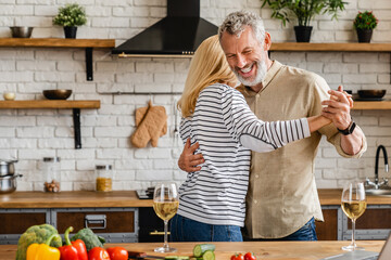 Romantic senior couple having fun while dancing at home