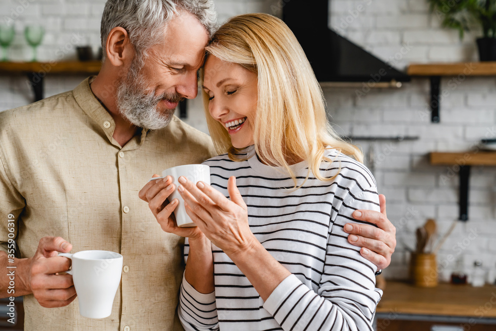 Wall mural affectionate mature couple bonding and enjoying cup of coffee