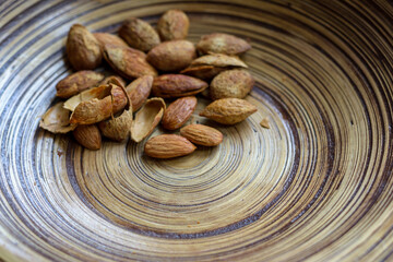 close up of some almonds in bamboo wood bowl with copy space for text or design. - 355906340