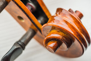 Closeup of beautiful aesthetic carving violin scroll at the end of the neck. The scroll motif is a very ancient and universal symbol throughout the world which designed by using Fibonacci Sequence.