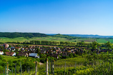 Fototapeta na wymiar Scenic view from the vineyards of the village Unterjesingen to the chapel St. Remigius (Wurmlinger Kapelle) at a day with clear blue sky.