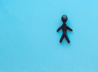 Flat lay  black, yellow, white paper people holding hands on blue background, top view. Unity concept. Stop racism, black lives matter, social exclusion message, misunderstanding, denial of society.