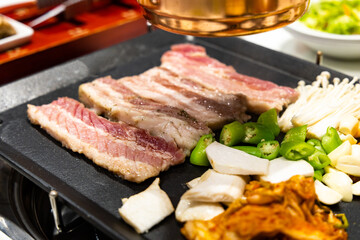 Korean BBQ Raw Pork on the Grill with Kimchi.