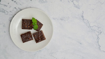 Homemade chocolate brownies in white plate on white stone background, Top view