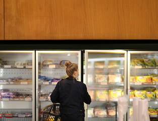 supermarket shopping, face mask and gloves,Woman choosing frozen food from a supermarket freezer