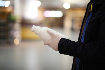  face mask and gloves,shopping in supermarket, reading product information,bottle of milk