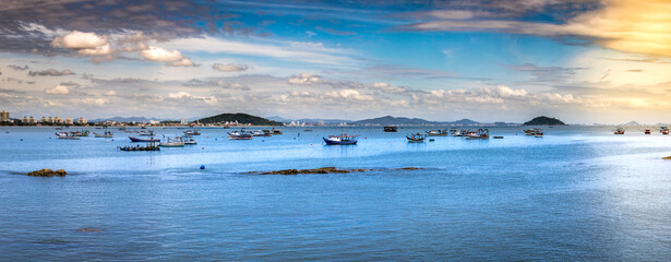 
Blue sea with anchored fishing boats and blue sky