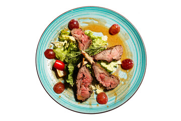 Roasted beef with lettuce on a plate isolated on a white background