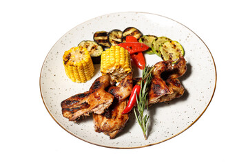 Grilled chicken wings with vegetables on a white background
