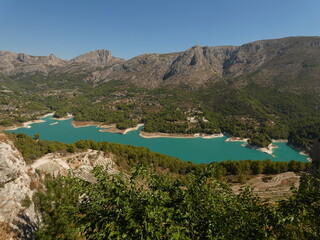 Fototapeta na wymiar Guadalest Reservoir (El embalse de Guadalest) - emerald green waters surrounded by mountains, Alicante province, Spain