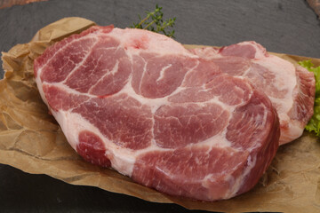 Raw pork steak over wooden board