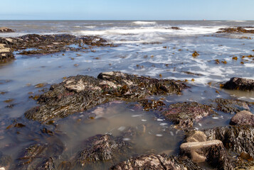 Rocky beach water waves with slow shutter motion blur