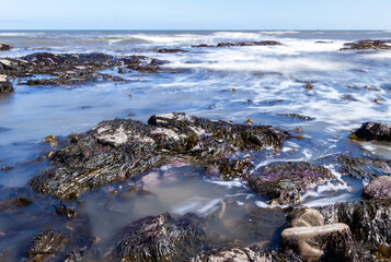 Rocky beach water waves with slow shutter motion blur
