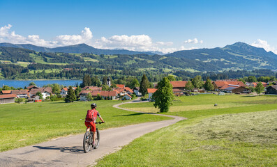 pretty senior woman riding her electrical mountain bike in warm  sunlight and enjoying the...