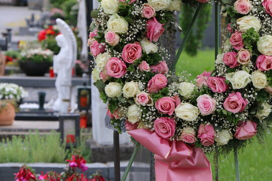 Ein Blumenkranz aus Rosen nach einer Beisetzung an einem Friedhof