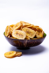 Healthy snack, crispy dehydrated unsugared banana chips in bowl on white background