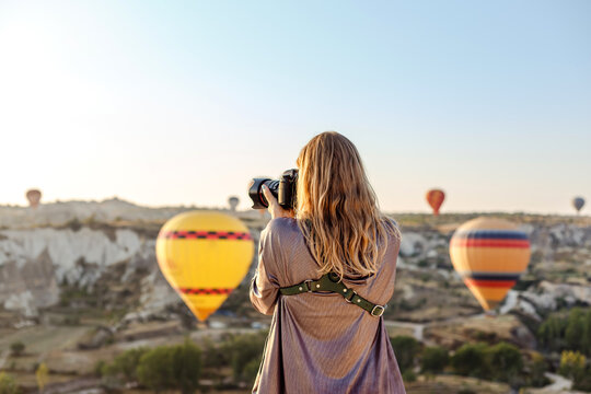 Woman photographer takes pictures of flying hot air balloon