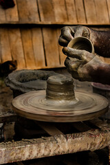 During the day a potter is making a clay pot.