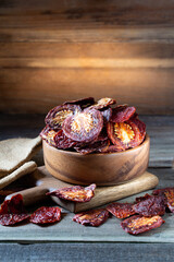 Sun dried tomatoes in round bowl on wooden board