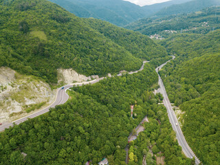 Mountain winding zig zag road. Top aerial view: cars driving on road from above.