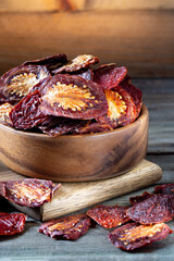 Sun dried tomatoes in round bowl on wooden board