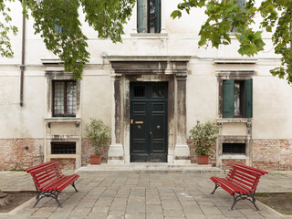 Red benches and building facade, Venice, Italy