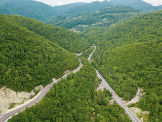 Mountain winding zig zag road. Top aerial view: cars driving on road from above.