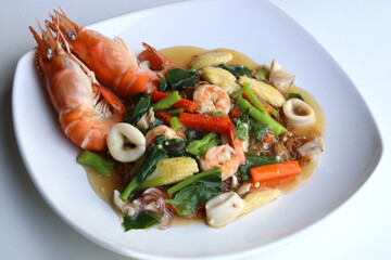 Wide Rice Noodles with Seafood in Gravy Sauce (Rad-Na Taley) served on a white plate. Put on the white table Ready to eat