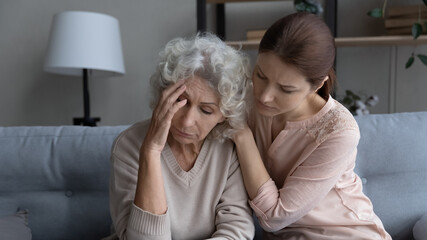 Supportive grownup girl hug comfort caress upset lonely elderly 60s mother mourning at home, caring...