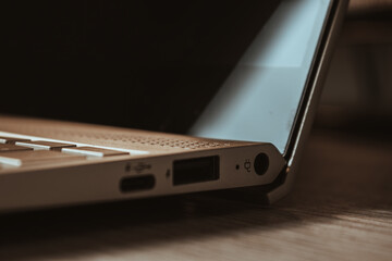 Side of Laptop on wooden desk