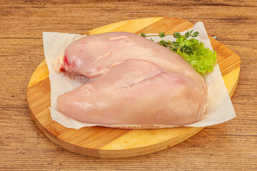 Raw chicken breast over board