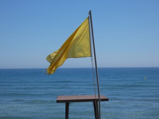 Yellow warning flag on the beach, La Cala de Mijas, Spain