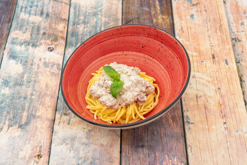 Red plate of spaghetti carbonara