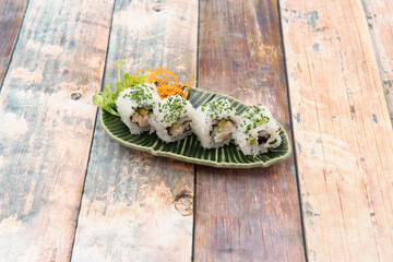 Ration of uramaki on wooden table