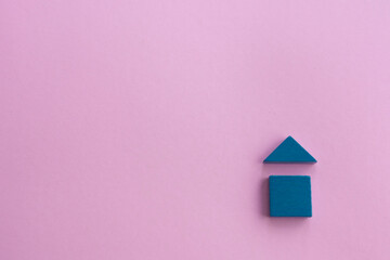 Obraz na płótnie Canvas wooden house made of wooden geometric details on a pink background. Family home concept