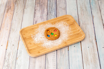 Cookie with sparks of m&m on wooden table