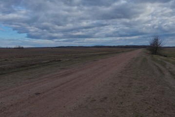 A dirt road among the fields in the evening. Autumn landscape.