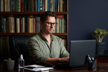 Handsome man working at his workplace. Work from home.